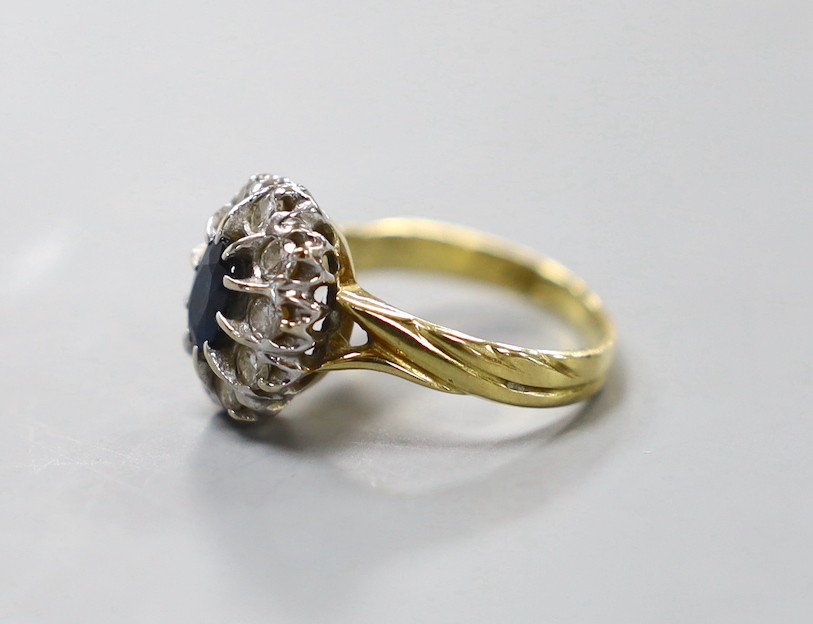 A modern 18ct gold, sapphire and diamond set oval cluster ring, size L, gross weight 4.6 grams.